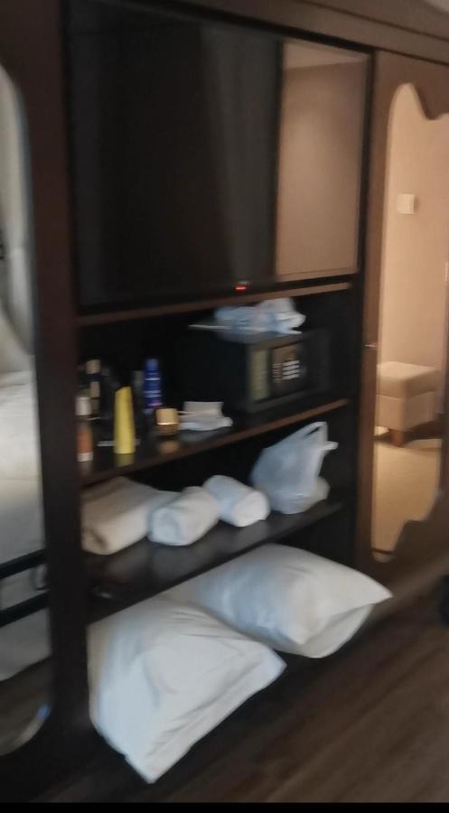 Buona Vitta Gramado Resort & Spa By Gramado Parks Exterior photo The photo shows a piece of furniture, likely a shelving unit or cabinet, with several items on it. There is a television mounted on top. Below the TV, there is a microwave and a small safe. The shelves contain various toiletries and personal care pro