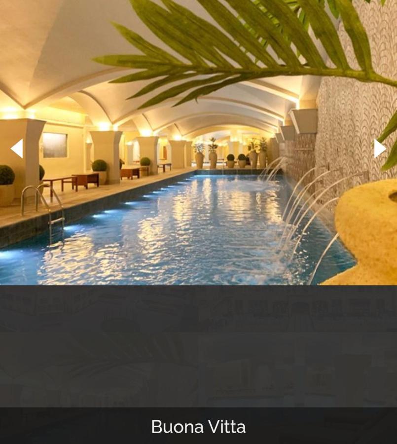 Buona Vitta Gramado Resort & Spa By Gramado Parks Exterior photo The photo depicts an elegant indoor swimming pool area. The pool is illuminated with lights along its edge, and there are gentle water features creating a calming atmosphere. The ceiling has an arched design, and the space is decorated with plants an