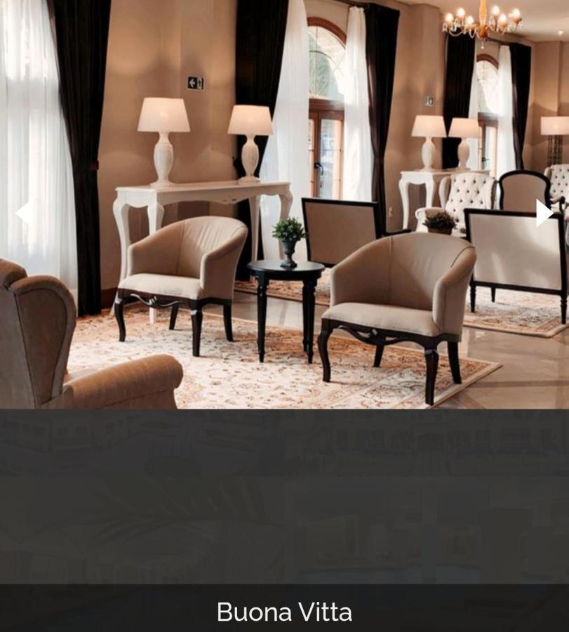Buona Vitta Gramado Resort & Spa By Gramado Parks Exterior photo The photo shows a stylish and inviting interior space, likely a lounge or waiting area. There are beige upholstered armchairs arranged around a small black table. A decorative plant is placed on the table. Behind the chairs are light-colored walls wi