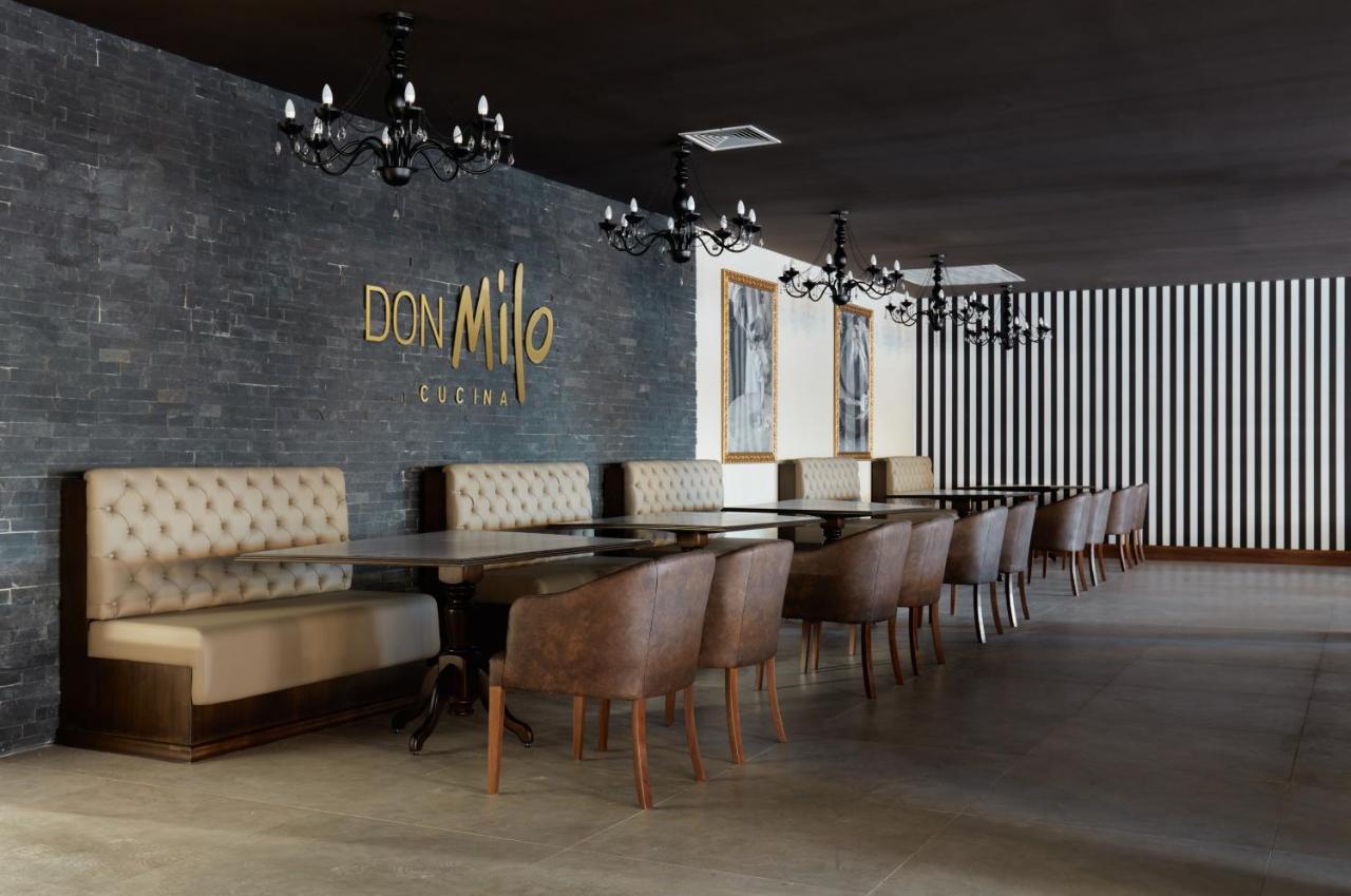 Buona Vitta Gramado Resort & Spa By Gramado Parks Exterior photo The photo showcases an interior of a restaurant named "Don Milo." The design features a modern and sophisticated look with a mix of textures and colors. 

On one side, there are upholstered booths in a neutral tone, creating a comfortable dining area