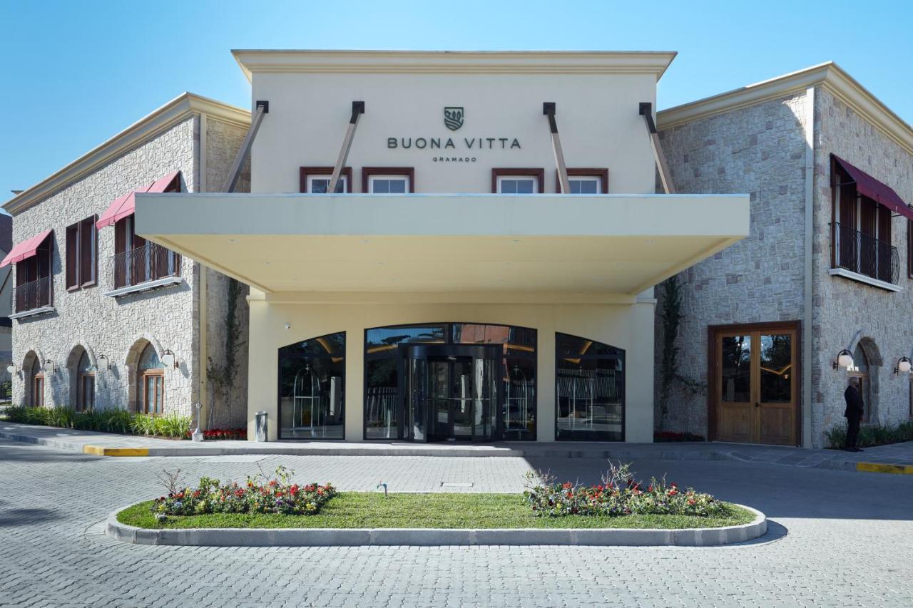 Buona Vitta Gramado Resort & Spa By Gramado Parks Exterior photo The photo shows a modern building with a prominent entrance marked by a large awning. The facade features a mix of stone and stucco materials, giving it an elegant and contemporary look. The name "BUONA VITTA" is displayed prominently above the entra