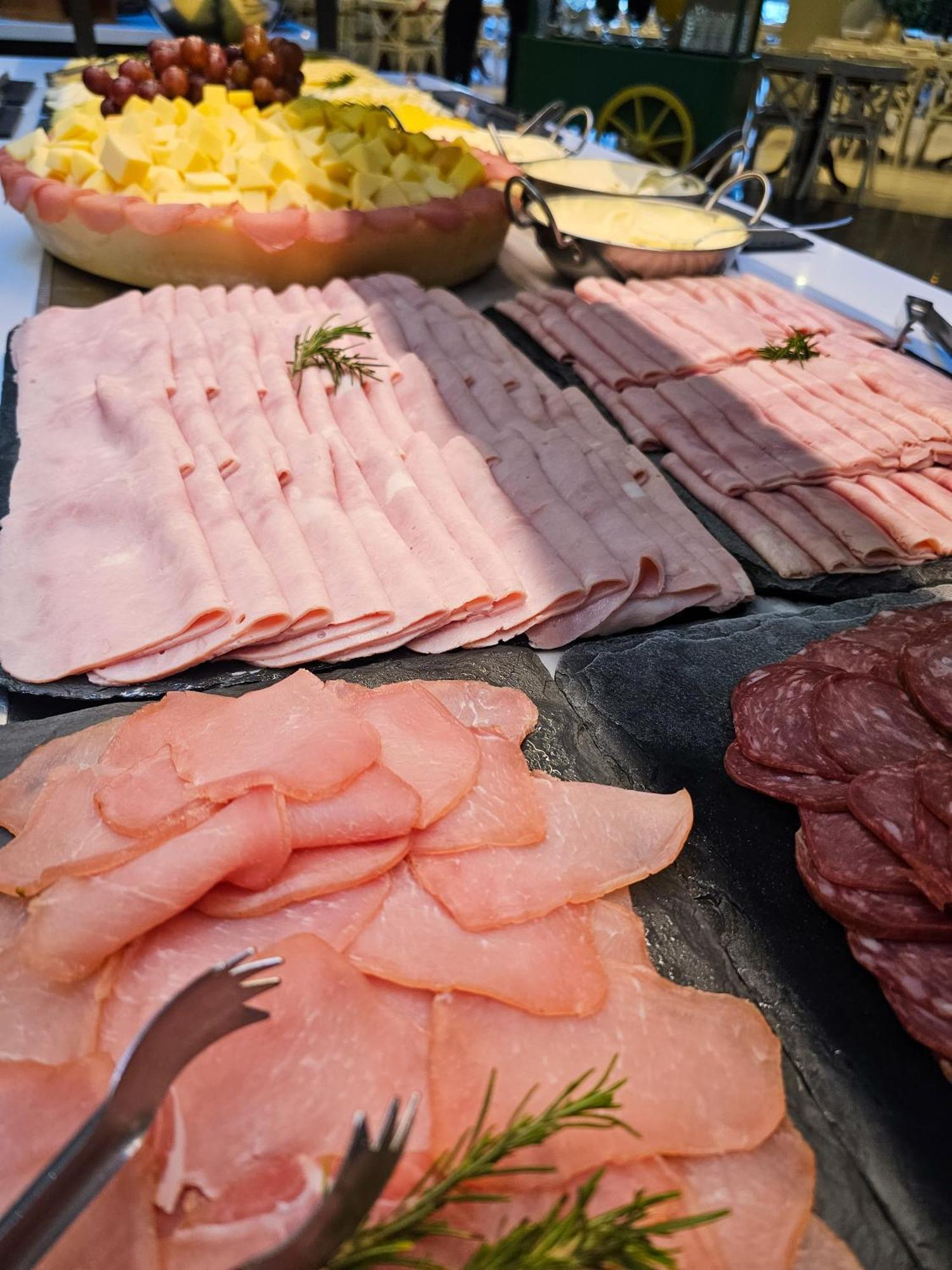Buona Vitta Gramado Resort & Spa By Gramado Parks Exterior photo The photo shows a display of various types of sliced deli meats arranged on a flat surface. There are several layers of thinly sliced, pale-colored meats, likely including ham or turkey, organized neatly in parallel rows. Additionally, there are slic